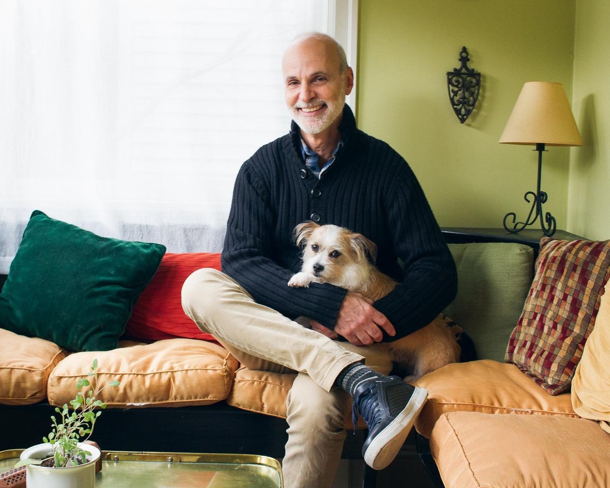 Life coach posing with his dog in a kitchen